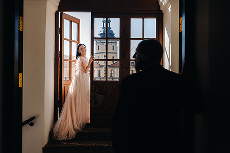 在内斯维日市古老城堡阳台上的 优美结婚情侣婚纱面纱女性房间已婚奢华戏服裙子新娘女士图片