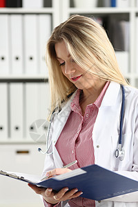 美丽笑容的女医生拿着剪贴板考试文档疾病职业服务测试帮助护士诊断病人图片