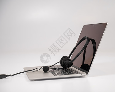 在笔记本电脑键盘上的耳机 白色背景服务工作室服务台办公室工作麦克风技术代理人电话商业图片