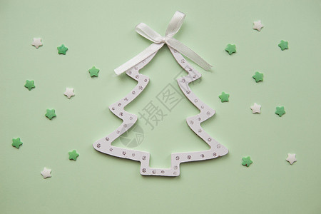 圣诞装饰品装饰背景 装饰性木制白色圣诞树玩具 形状为绿色背景上的圣诞树 顶视图 平躺风格庆典新年手工作品假期传统季节手套小样图片