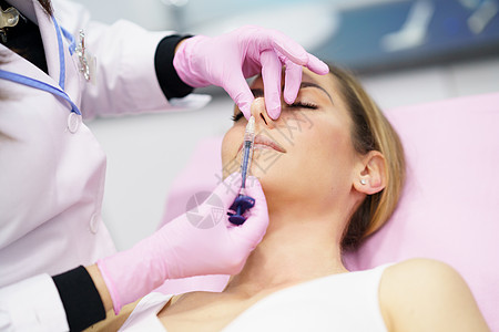 医生在病人的鼻子中注入了血压酸 以进行犀利成形术美容师装饰女性线程胶原程序女士治疗化妆品塑料图片