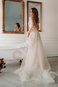 一个穿着婚纱的豪华新娘 清晨在内地家具仪式妻子女士假期处女膜庆典公寓裙子房间图片