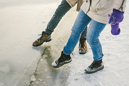 试脚险 试近岸薄冰 一对恋人沿着结冰的湖边散步 将脚踩在冰上天气家庭男人团体风险假期变化液体警告身体图片
