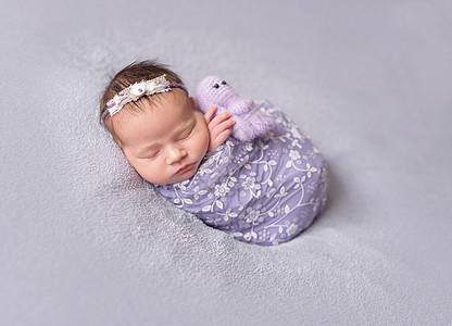 正在睡觉的新生婴儿女婴快乐睡眠休息压痛冒充紫色孩子童话玩具微笑脸高清图片素材