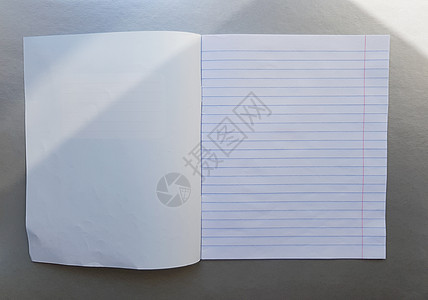 在灰色的桌子上用钢笔打开学校笔记本 阳光从窗户射进来 一张空白的白色笔记本 用于书写 教育理念 复制空间 从上面看 平躺设计师大图片