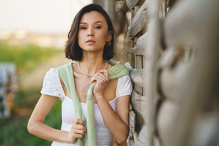 身着白裙子和绿水衣的亚洲妇女 在烟雾干燥棚附近摆姿势季节乡村草地女孩快乐烘干机冒充国家场地裙子图片