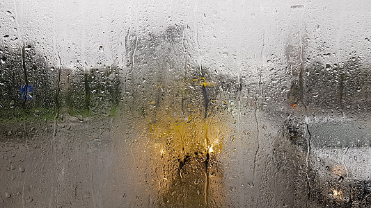 秋天汽车后窗下雨 从雨滴的汽车透过窗户 可以看到城市中行驶的汽车的道路内部视图 在后窗的视野中驾驶汽车斑点风暴反射速度运动车辆交图片