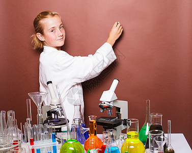 深思熟虑的女学生桌子烧瓶显微镜学生测试写作神童女性实验班级图片