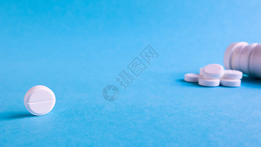 蓝色背景上的白色圆形药丸 桌上散落着白色药丸 医学 药学和医疗保健的概念 复制空间文本或徽标的空白空间流感治愈制药抗生素止痛药药图片