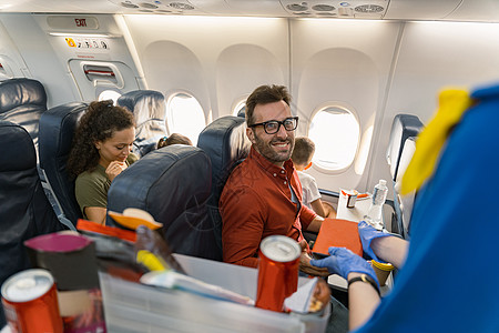 戴眼镜的快乐男人 在飞机上等午餐盒的时候图片
