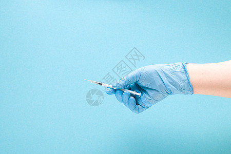 蓝色橡胶医用手套中的女手在蓝色背景复制空间 治疗和保健概念 糖尿病概念上握住胰岛素注射器医院医生诊所剂量疫苗液体注射疾病女性手臂图片
