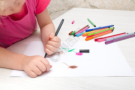 小女孩在桌上用毡尖笔在纸上画花艺术家画家童年教育彩笔艺术品绘画孩子蜡笔孩子们图片