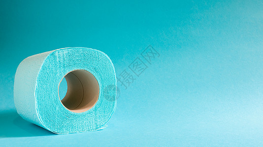 蓝色背景上的蓝色现代卫生纸卷 纸板套筒上的纸制品 用于卫生目的 由纤维素制成 带有便于撕裂的切口 浮雕图 复制空间产品配件材料组背景图片