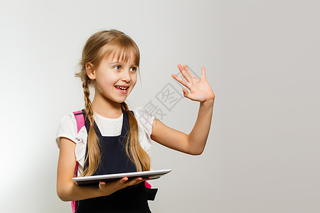 小女孩在白色墙壁背景上使用平板石牌童年测试药片笔记本远程教育青春期学习视频知识考试图片