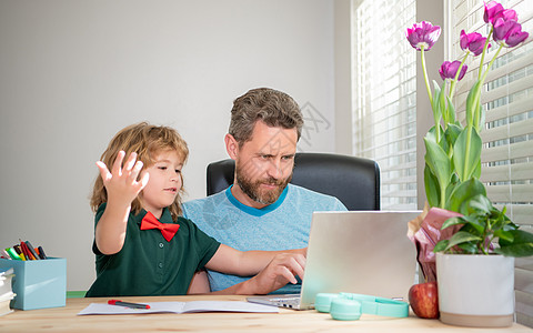 留胡子的爸爸或学校私人教师用现代笔记本电脑 电子学习教男孩儿子图片
