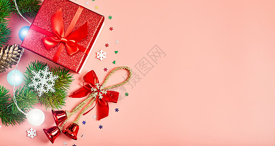 圣诞树枝带有礼品盒 装饰品和fir树枝的圣诞节粉红背景浆果盒子桌子荚蒾问候语雪花手套木头礼物包装背景