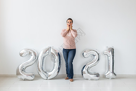 新年庆典和聚会概念年轻快乐的女子 白底带接近银2021气球的闪光灯季节女孩女士风格魅力微笑空气成人数字假期图片
