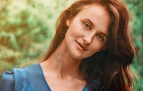 迷人的褐色女人的肖像发型绿色女孩公园女士微笑黑发女性阳光蓝色图片