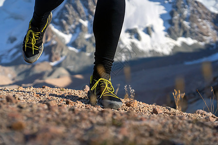 人正在山上奔跑 双腿紧紧男人日落峡谷男性跑步运动鞋气候运动内衣石头图片