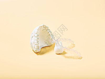 黄色背景中的正畸牙科主题 适用于正畸牙科治疗的透明隐形牙齿矫正器或牙套面具医生设备面罩药品保护科学病人牙医矫正图片