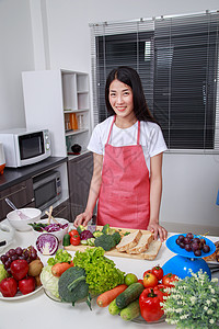 在厨房厨房做饭的年轻美少女食物女孩水果主妇快乐沙拉橙子女士食谱家庭图片