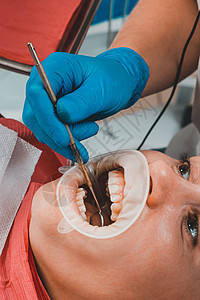 口腔卫生 牙医办公室的一名妇女 在从塔塔刷牙时使用履带器诊所医生牙刷石头乐器技术员丹参美白女性卫生员图片