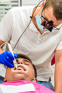 牙科诊所 私人诊所 牙医使用双筒望远镜以获得最佳效果和工作 去除牙垢的过程鞑靼硬斑块外科卫生病人望远镜超声波牙齿牌匾工具图片