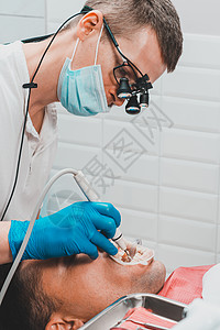 牙科诊所 私人诊所 牙医使用双筒望远镜以获得最佳效果和工作 去除牙垢的过程检查预防病人办公室治疗卫生牙龈斑块乐器望远镜图片