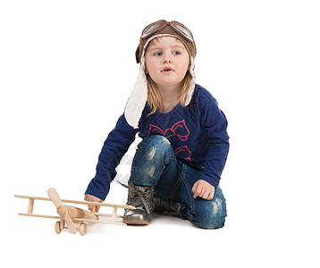 穿着木制飞机驾驶帽的可爱小女孩玩具照片帽子女孩飞机微笑空军工作室孩子图片