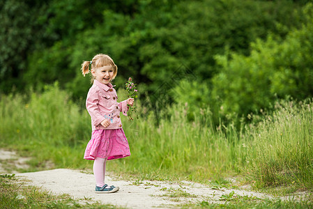 草地上的可爱小女孩喜悦乐趣绿色孩子快乐森林头发后代眼睛女孩图片