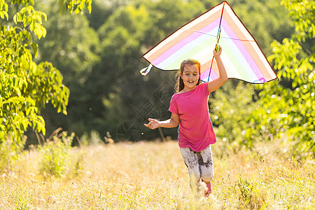 小女孩带着风筝在户外放风笛喜悦跑步快乐太阳幸福操场彩虹女性女孩农村图片