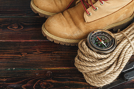 山靴和木木板板上的徒步用具冒险旅游地面假期皮革罗盘项目靴子高架背包图片