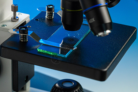 检查玻璃样品的显微镜镜头近照照片研究微生物学生物样本镜片实验室盘子乐器药品光学图片