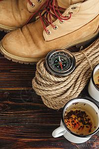 山靴和木木板板上的徒步用具桌子生活旅游罗盘假期乡村高架探险家背包旅行图片