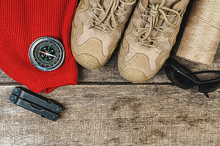 山靴和木木板板上的徒步用具旅游罗盘冒险运动桌子背包生活配件探险家齿轮图片