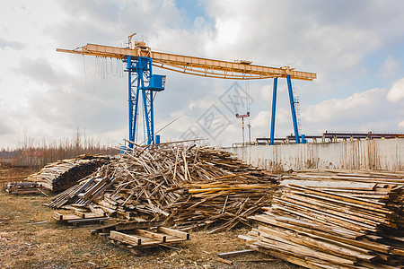 工业区 建筑工地和堆叠成木柴废料的建筑工地以及高架起重机图片