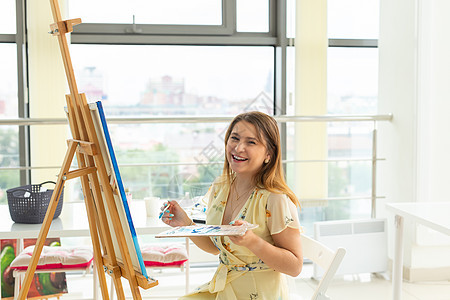 艺术课和绘画概念在工作室从事绘画工作的女艺术家眼睛教育作坊画架女性热情班级爱好艺术品学生图片