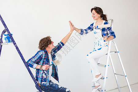 团队合作 翻新和重新装修的概念  坐在梯子上涂着油漆的年轻男女配件家庭胶水改造女孩衬衫夫妻艺术女士男性图片