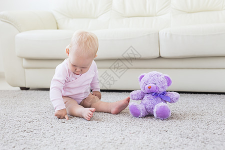 穿着粉色衣服坐在地毯上的小可爱女婴女儿童年孩子公主女性乐趣微笑女孩卧室男生图片