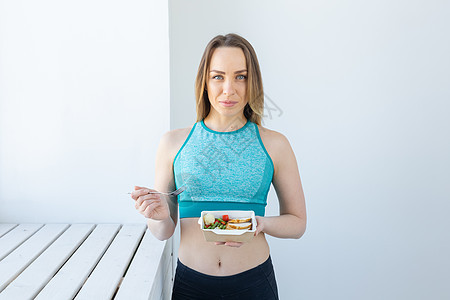 健康饮食 节食和健身概念锻炼后吃蔬菜和肉的年轻女性皮肤食物烹饪素食主义者身体营养午餐厨房女孩桌子图片
