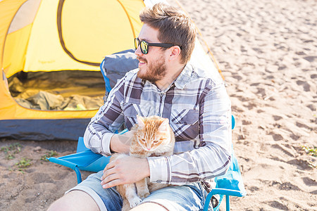 人 旅游和自然概念     持猫的男子野餐太阳镜闲暇游客微笑幸福乐趣假期露营者旅行图片