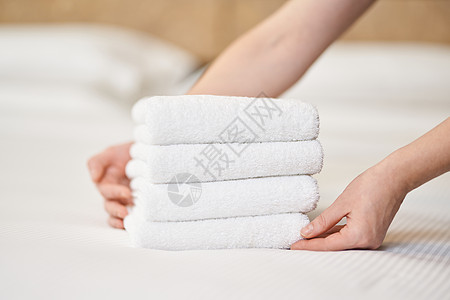 将毛巾放在旅馆公寓的床铺上图片