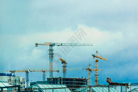 现场建造塔式工业起重机 建筑设计 开发和城市建筑创作工作蓝色天空生长住房日落技术进步财产公寓安全图片