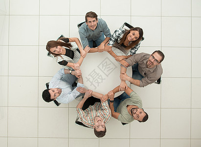 顶视图 坐在圆桌旁的单一业务团队朋友们男人会议力量合伙圆圈商业联盟友谊手臂图片