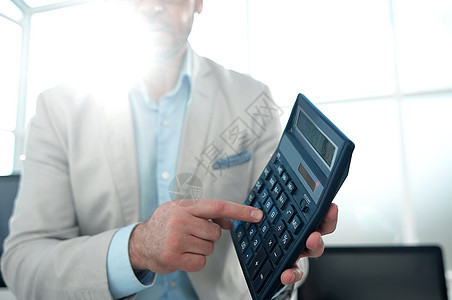 自信的商务人士 指向计算器金融领带投资男人桌子商务笔记本男性工作人士图片
