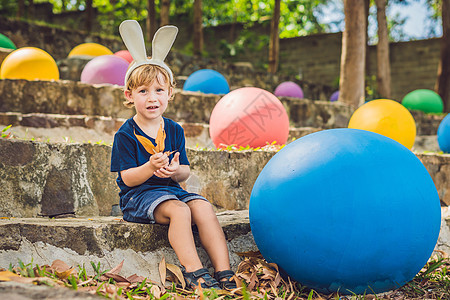 可爱的小男孩 长着兔耳朵 在户外玩传统的复活节彩蛋 庆祝复活节假期 蹒跚学步的发现 五颜六色的鸡蛋孩子们童年兔子孩子假期家庭公园图片