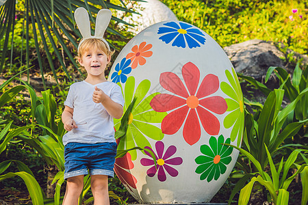可爱的小男孩 长着兔耳朵 在户外玩传统的复活节彩蛋 庆祝复活节假期 蹒跚学步的发现 五颜六色的鸡蛋童年兄弟婴儿篮子假期姐姐家庭兔图片