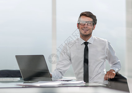 生意人坐在宽敞的办公室里商业人士互联网工人电话经理电脑男性手机工作图片