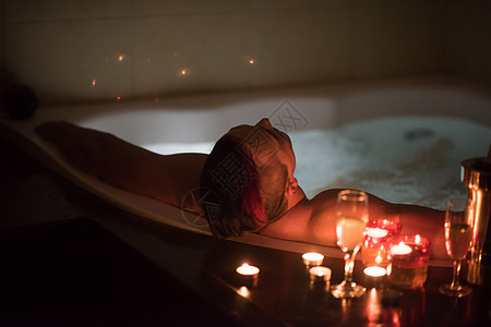 男人在按摩浴缸里放松微笑奢华男性气泡休息漩涡眼镜水疗商业温泉图片