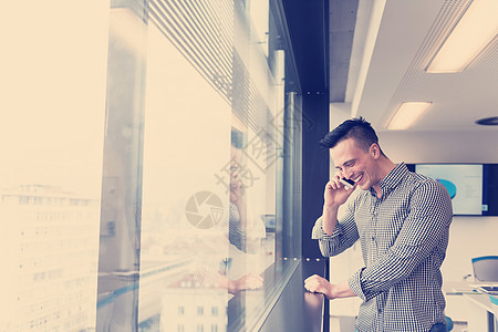 年轻商务人士在办公室用智能手机讲话管理人员技术经理电话幸福互联网商务约会成人建筑图片